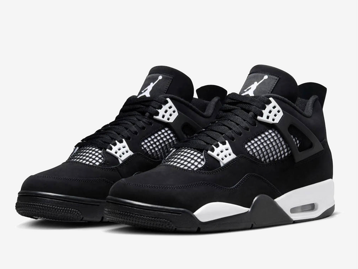 Exclusive Air Jordan 4 sneakers in a black and white colour scheme, featuring a black nubuck upper with white plastic netting on the sides and forefoot.
