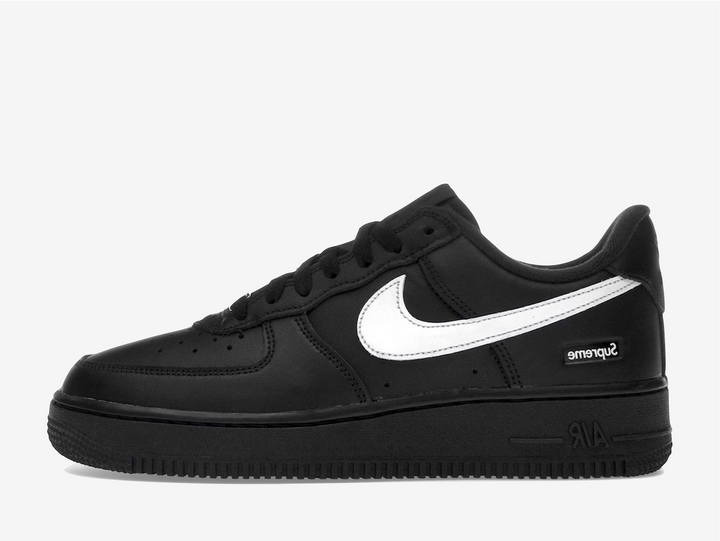 The Nike Air Force 1 Low x Supreme Black/White (FW25) fuses street-wear pedigree with timeless basketball heritage — its rich black full-grain leather upper is sharply contrasted by a crisp white Swoosh and co-branded Supreme details on the tongue, lace lock, and footbed. Built on the classic Air Force 1 Low silhouette with premium materials, perforated toe panel and plush lining, this drop delivers that elevated simplicity that wearable hype should.