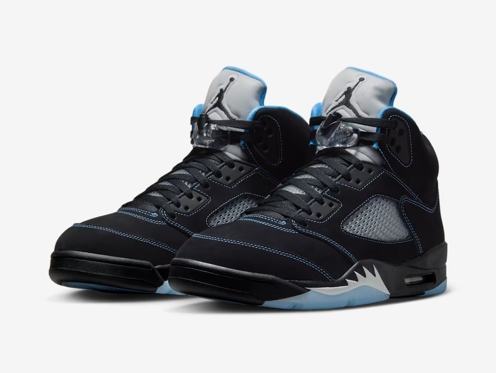 Black nubuck is utilised on the upper, accented with contrast stitching and equipped with translucent quarter panel netting. University Blue textile lines the collar, matching the embroidered Jumpman that adorns the heel. A second Jumpman icon decorates the silver reflective tongue. The sneaker is mounted on a black polyurethane midsole with white shark tooth detailing and a visible Air-Sole unit in the heel. A translucent herringbone-pattern rubber outsole provides grippy traction underfoot.