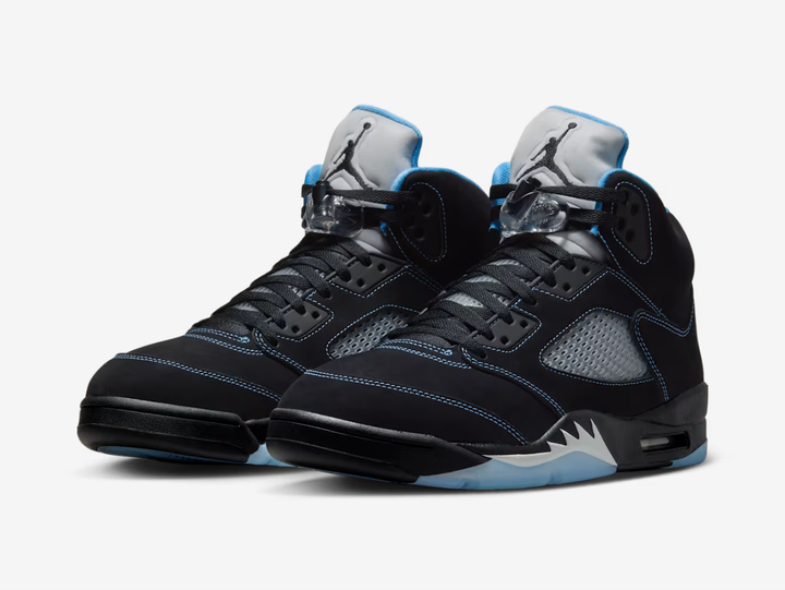 Black nubuck is utilised on the upper, accented with contrast stitching and equipped with translucent quarter panel netting. University Blue textile lines the collar, matching the embroidered Jumpman that adorns the heel. A second Jumpman icon decorates the silver reflective tongue. The sneaker is mounted on a black polyurethane midsole with white shark tooth detailing and a visible Air-Sole unit in the heel. A translucent herringbone-pattern rubber outsole provides grippy traction underfoot.