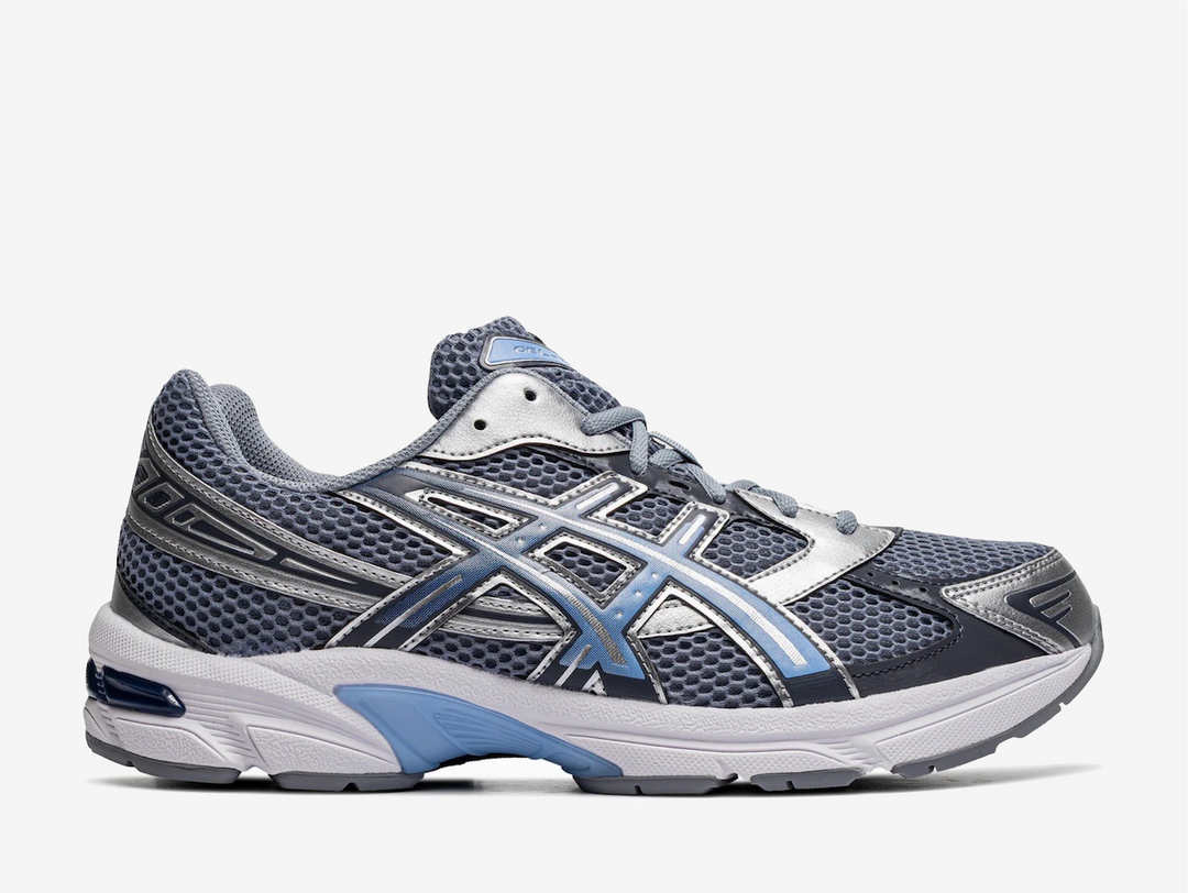 This techy retro running shoe dons a light grey open mesh upper with glossy silver synthetic overlays, staying true to its late 2000s design. A light blue to navy gradient effect animates the Tiger Stripes on the side panels, complementing the ASICS brand labels on the tongue, rear, and insole. The lightweight EVA midsole encases a visible GEL insert in the heel for maximum comfort, reinforced by a TRUSSTIC shank plate for torsional support and stability.