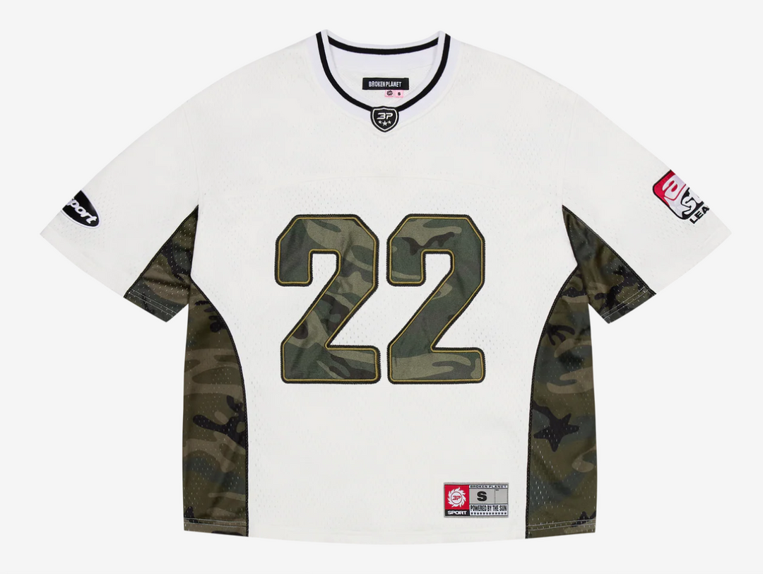 This jersey is made from a recycled polyester base and lining, offering a sustainable edge with a premium feel. Designed with a boxy fit for a modern, relaxed silhouette, it features satin appliqué embroidery paired with a silicone print on the back, delivering bold texture and depth. Metallic print graphics add a striking visual impact, while an embroidered neck patch and woven label complete the design with elevated detail.