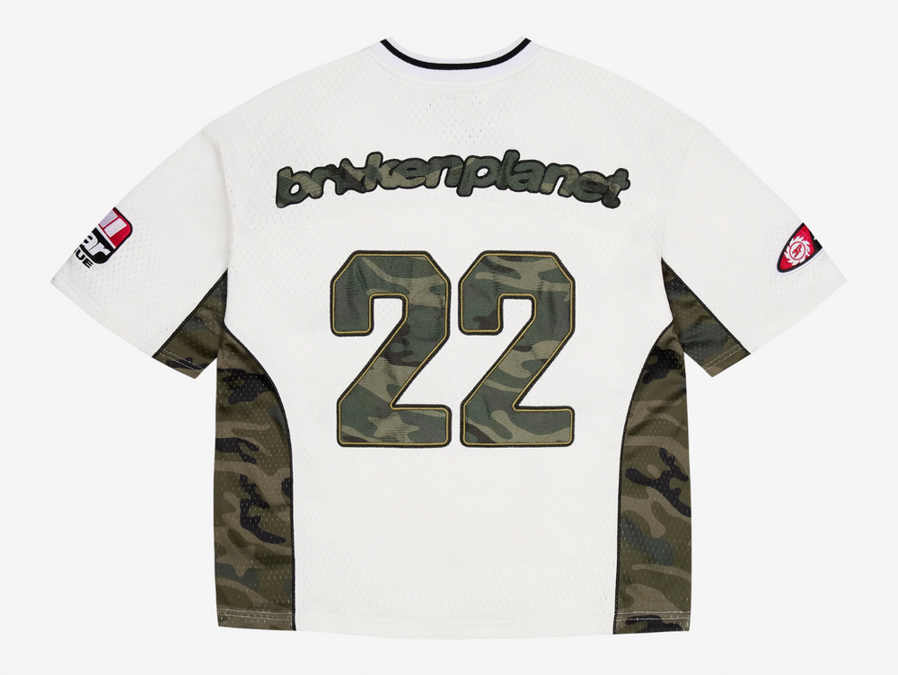 This jersey is made from a recycled polyester base and lining, offering a sustainable edge with a premium feel. Designed with a boxy fit for a modern, relaxed silhouette, it features satin appliqué embroidery paired with a silicone print on the back, delivering bold texture and depth. Metallic print graphics add a striking visual impact, while an embroidered neck patch and woven label complete the design with elevated detail.