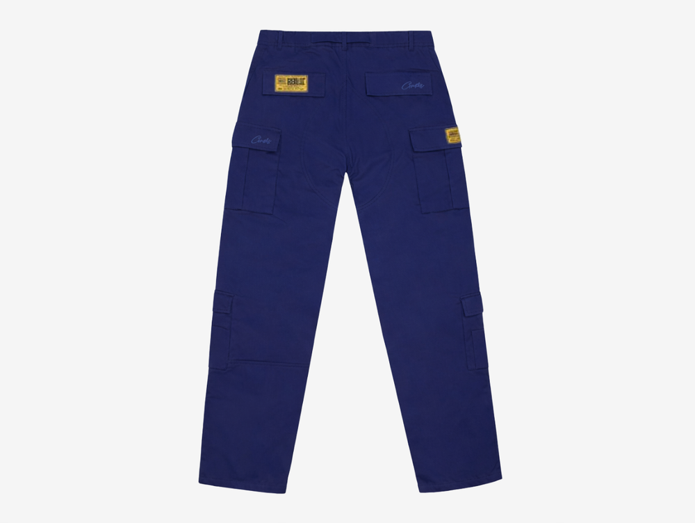 The Corteiz Alcatraz Guerillaz Cargo Trousers deliver a perfect blend of utility and streetwear style. Made from durable heavyweight fabric, they feature multiple functional cargo pockets, an adjustable waist belt, and bold branded detailing, including the signature Alcatraz graphic. Presented in a deep navy base with contrasting white accents, these trousers offer everyday comfort, practical design, and unmistakable Corteiz identity.