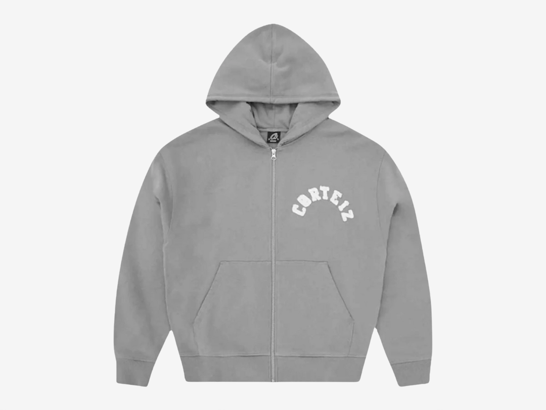 Built with premium quality and clean everyday styling, the Corteiz Colly Arch Logo Zip Up Hoodie is crafted from heavyweight 440GSM 100% cotton for a structured yet comfortable feel. Designed with a boxy, dropped-shoulder fit, it features a raw edge Corteiz logo on the left chest, durable overlock stitching throughout, and high-quality YKK metal zippers. Finished with a soft fleece-lined interior, ribbed cuffs and hem, this hoodie delivers warmth and durability in a versatile grey colourway.