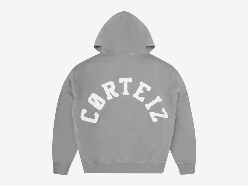 Built with premium quality and clean everyday styling, the Corteiz Colly Arch Logo Zip Up Hoodie is crafted from heavyweight 440GSM 100% cotton for a structured yet comfortable feel. Designed with a boxy, dropped-shoulder fit, it features a raw edge Corteiz logo on the left chest, durable overlock stitching throughout, and high-quality YKK metal zippers. Finished with a soft fleece-lined interior, ribbed cuffs and hem, this hoodie delivers warmth and durability in a versatile grey colourway.
