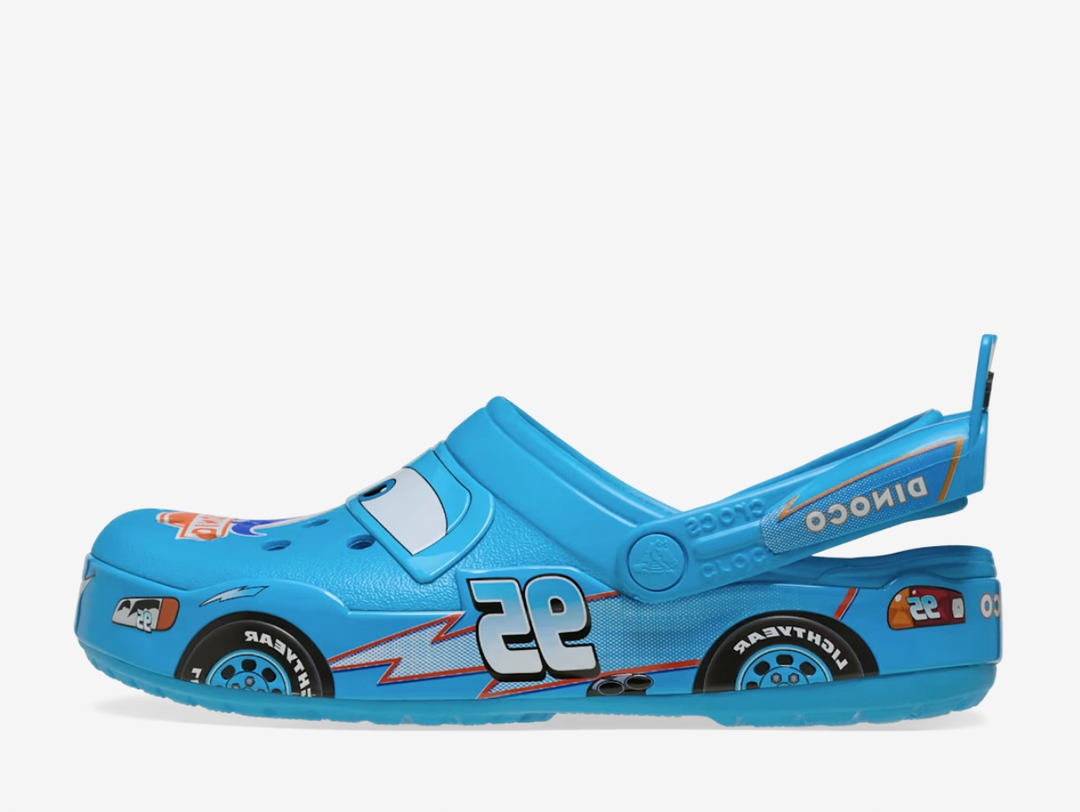 The Crocs Classic Clog Dinoco brings a bold racing-inspired look to the iconic clog silhouette, finished in bright blue with Dinoco graphics, racing numbers and character-inspired detailing throughout. Lightweight Croslite™ construction, ventilation ports and an adjustable heel strap provide the signature comfort and easy fit Crocs are known for.