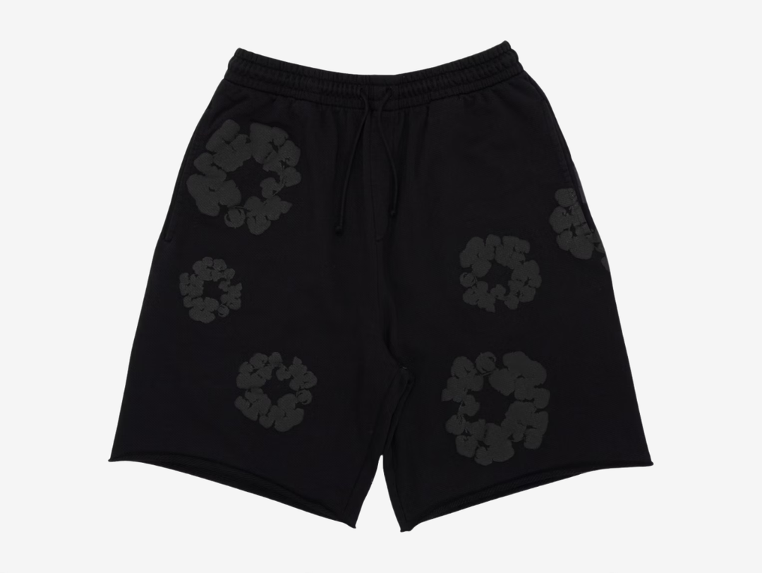 The Monochrome Black colourway features a black base finished with the iconic cotton wreath graphic printed throughout in tonal black. The subtle monochrome design keeps the look clean while still highlighting the brand’s signature motif. Finished with an elasticated waistband and side pockets, the Denim Tears Cotton Wreath Shorts Monochrome Black blend statement design with everyday wearability.