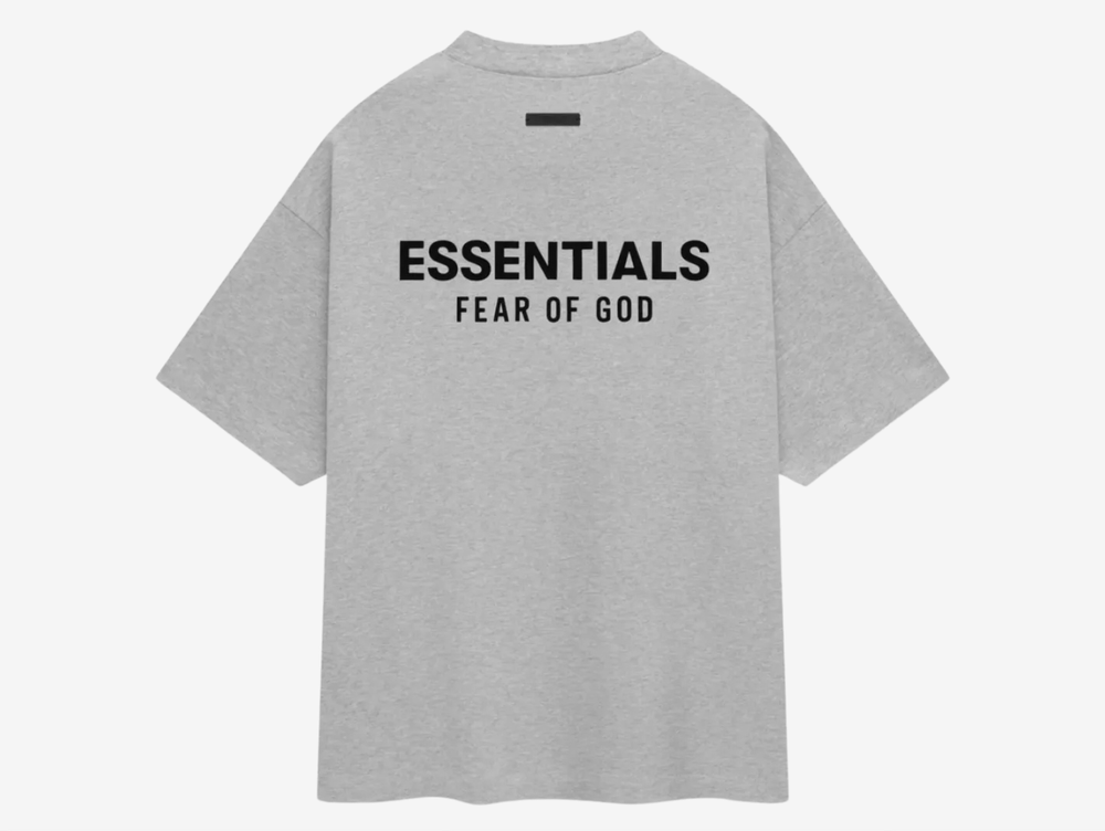 The t-shirt has a minimalistic aesthetic with thoughtful details such as the "Essentials Fear of God" logo placed on both the chest and back with an understated rubberized tag at the back collar. The colorway of the gray of the material and the black logo texts adds to the minimal look and makes it a versatile piece.