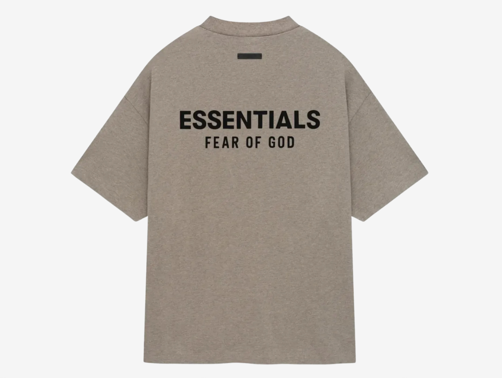 The tee showcases an oversized fit with a ribbed crew neck, short sleeves, and dropped shoulders. Sticking to the minimalist theme, the T-shirt features subtle but impactful branding on the left chest and back, showcasing the "ESSENTIALS FEAR OF GOD" soft-touch logo graphics in black. The Heather Gray tee finishes with a rubber logo patch on the back.
