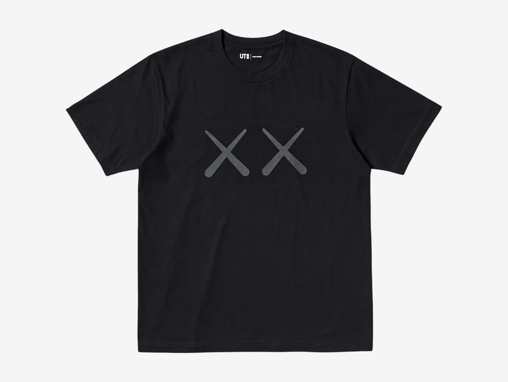 Black crewneck T-shirt, back view, featuring a red 'Andy Warhol' signature logo with grey KAWS 'XX' eyes printed below it, above a large tonal gray print of Andy Warhol's spiky self-portrait face, centered on the upper back.