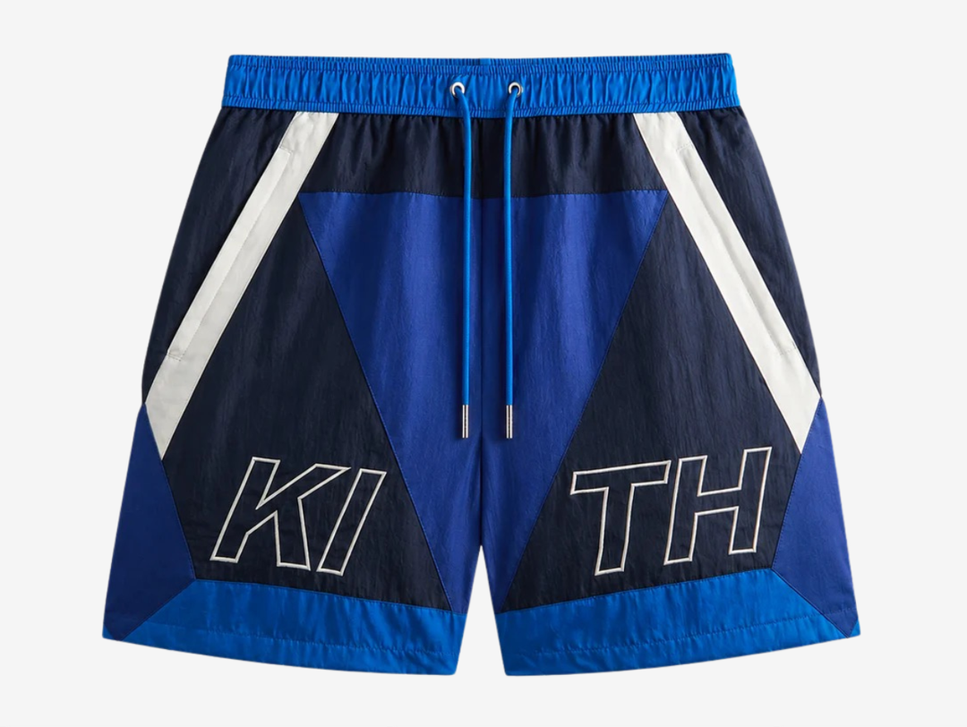 Kith Washed Nylon Shorts in Layer Blue, featuring a lightweight washed nylon construction, relaxed fit, elasticated waistband, and practical storage pockets. Finished in a versatile blue colourway with subtle Kith branding and a clean streetwear aesthetic.