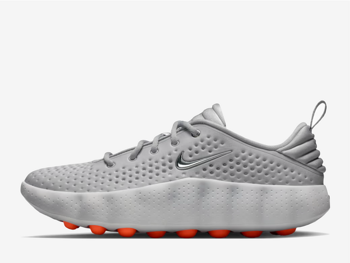 This 002 dons a grey knitted textile upper with engineered perforations for a lightweight and breathable feel. A metallic silver Swoosh rests on the padded tongue and sidewall, complementing the chromed-out Nike branding on the rear. The traditional lacing system and puffy heel counter provide a secure fit. The chunky foam midsole delivers excellent cushioning and impact absorption underfoot. 22 spherical orange foam nodes target your foot’s pressure points, offering a mind-altering experience.