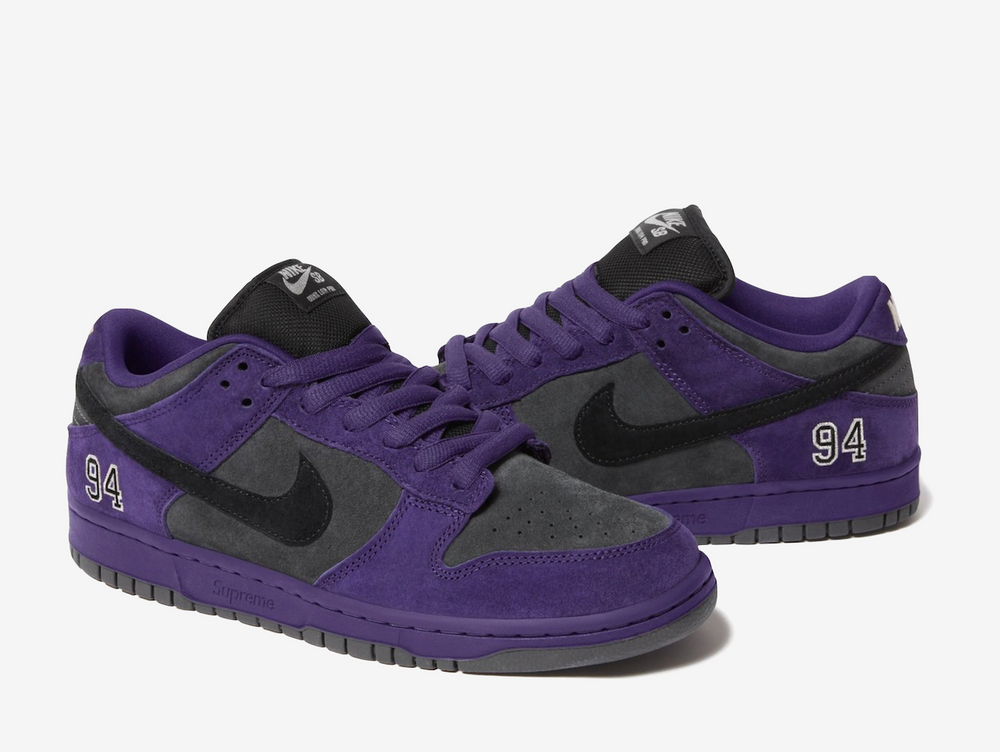 This skate shoe features a dark grey suede upper with a black Swoosh and purple accents. An embroidered “94” on the lateral foxing nods to the brand’s Manhattan origins, while a debossed Supreme label, co-branded sockliners, and orange hangtag add signature touches. Classic SB details appear on the heel tabs and puffy tongue, with Zoom cushioning in the heel for impact protection. Extra black laces offer versatile styling for skate or casual wear.