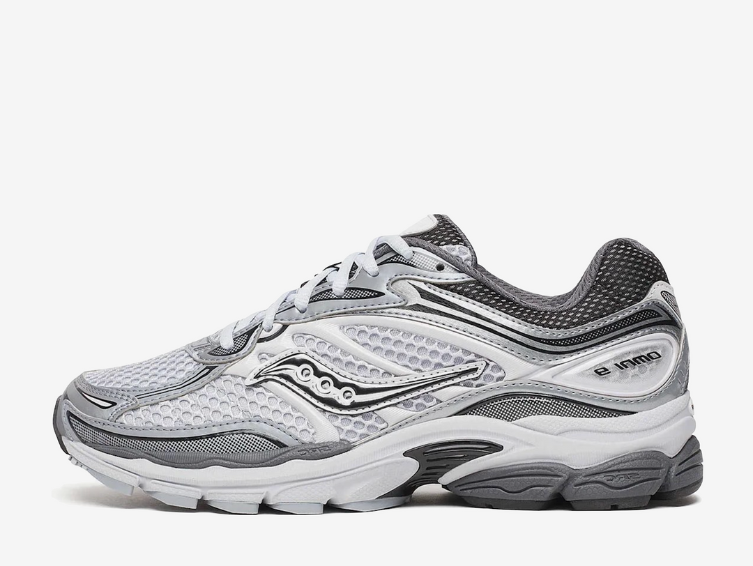 Saucony ProGrid Omni 9 Microchip sneaker featuring a versatile grey colourway, breathable mesh upper, premium synthetic overlays, ProGrid cushioning technology, and signature Saucony branding. Designed for all-day comfort with a retro-inspired running silhouette and everyday wearability.