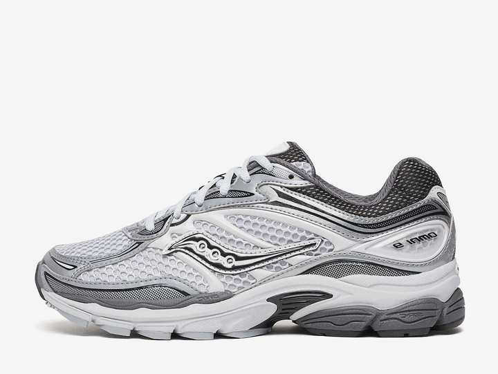 Saucony ProGrid Omni 9 Microchip sneaker featuring a versatile grey colourway, breathable mesh upper, premium synthetic overlays, ProGrid cushioning technology, and signature Saucony branding. Designed for all-day comfort with a retro-inspired running silhouette and everyday wearability.