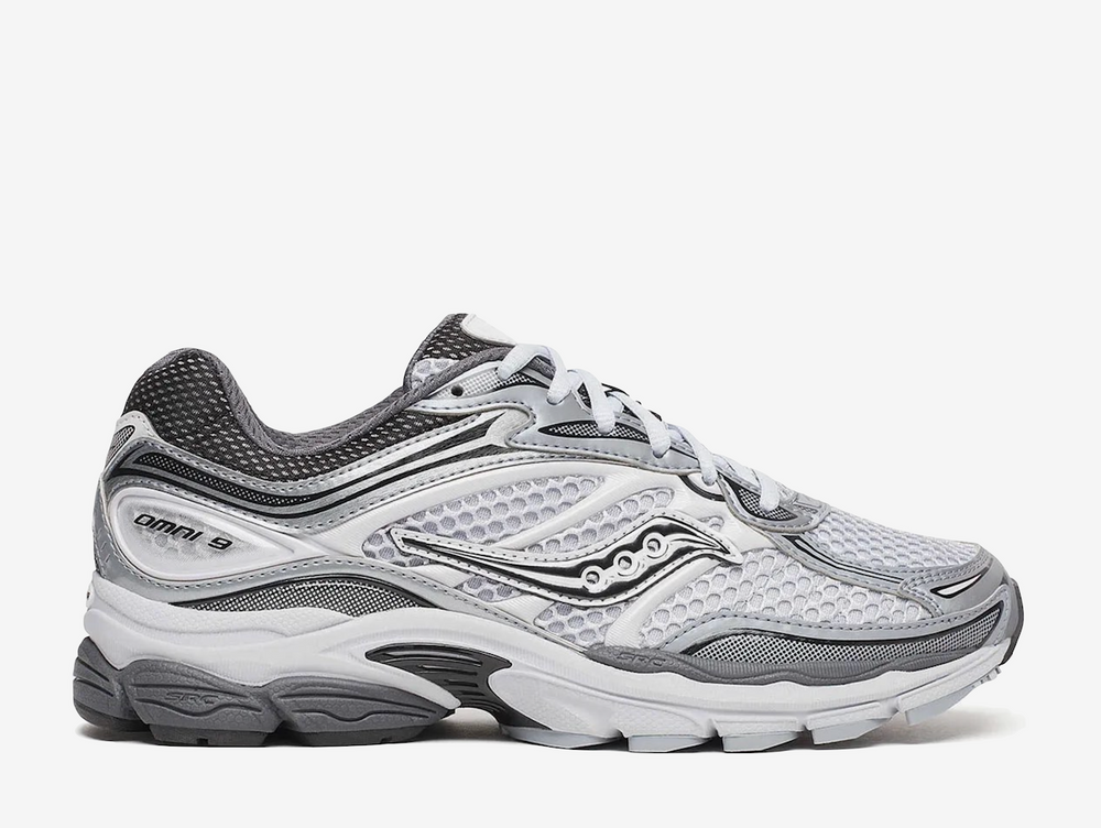 Saucony ProGrid Omni 9 Microchip sneaker featuring a versatile grey colourway, breathable mesh upper, premium synthetic overlays, ProGrid cushioning technology, and signature Saucony branding. Designed for all-day comfort with a retro-inspired running silhouette and everyday wearability.