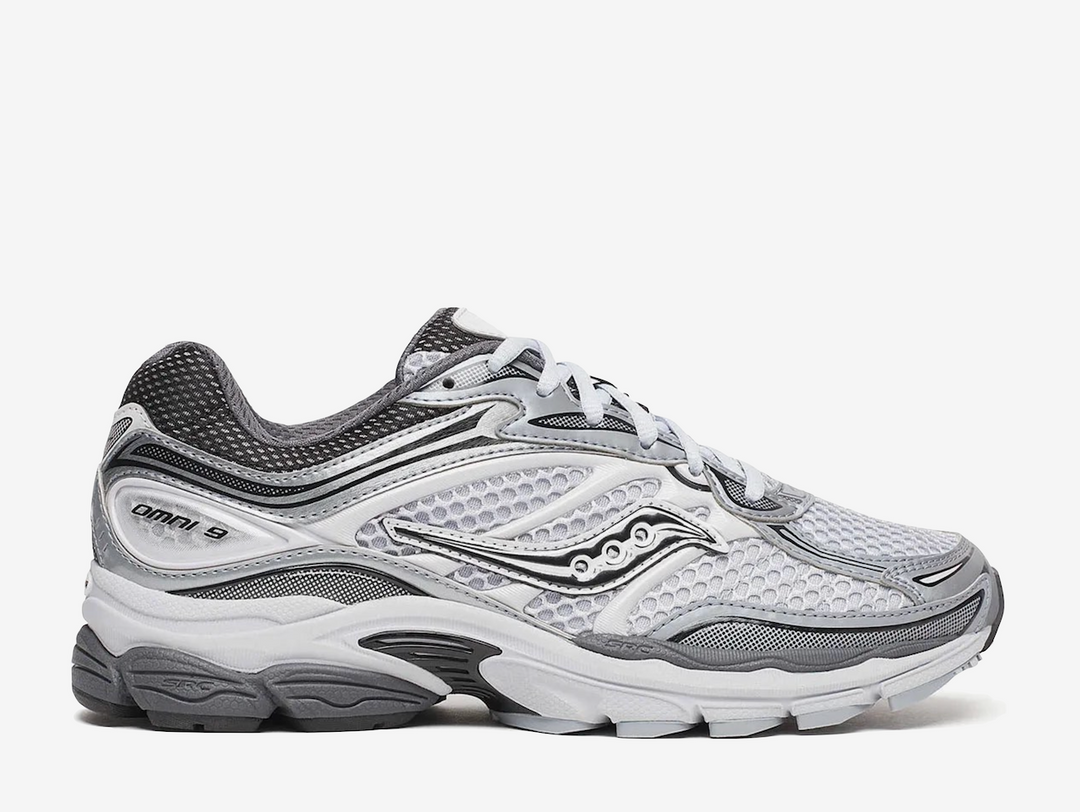 Saucony ProGrid Omni 9 Microchip sneaker featuring a versatile grey colourway, breathable mesh upper, premium synthetic overlays, ProGrid cushioning technology, and signature Saucony branding. Designed for all-day comfort with a retro-inspired running silhouette and everyday wearability.