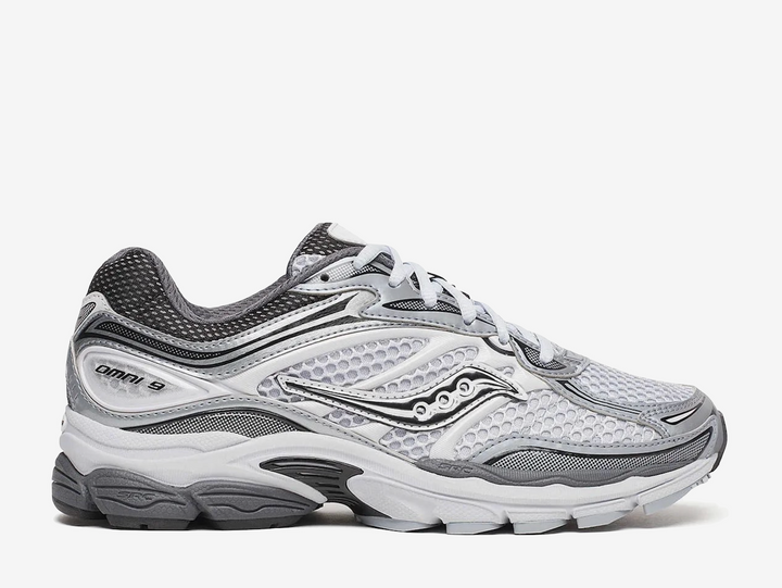 Saucony ProGrid Omni 9 Microchip sneaker featuring a versatile grey colourway, breathable mesh upper, premium synthetic overlays, ProGrid cushioning technology, and signature Saucony branding. Designed for all-day comfort with a retro-inspired running silhouette and everyday wearability.