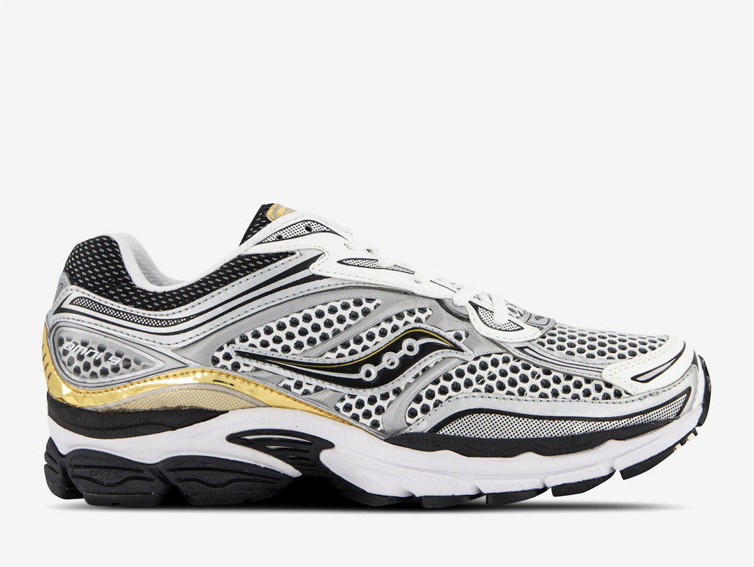 The Saucony ProGrid Omni 9 White Black Silver Gold revisits early two thousands running energy through bold contrast and metallic detail. White and black establish a familiar athletic base, while silver and gold accents introduce shine and depth across the layered upper. The ProGrid structure gives the silhouette presence, emphasizing performance heritage through visible form and proportion.