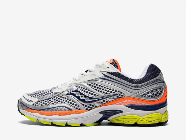 The Saucony ProGrid Omni 9 Silver Navy Orange combines silver mesh and overlays with navy detailing, bright orange accents and a volt outsole. ProGrid cushioning underfoot provides everyday comfort, while the bold colour blocking gives the retro runner a more energetic finish.