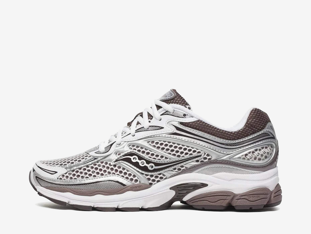 The Saucony ProGrid Omni 9 Silver White Brown features a breathable silver and white mesh upper with layered metallic overlays and muted brown accents. ProGrid cushioning and a chunky rubber outsole complete the pair with a comfortable feel and classic retro-running aesthetic.