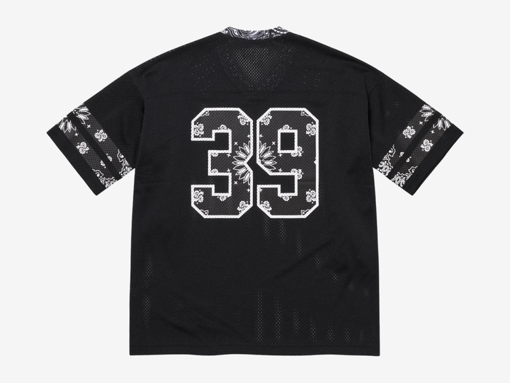 The Supreme Bandana Football Jersey Black fuses classic athletic design with the brand’s signature edge. Built on a breathable mesh base, the jersey is elevated with all-over bandana-inspired graphics that bring bold texture and street presence. Athletic striping and tackle-twill style branding nod to traditional gridiron uniforms, while the relaxed, boxy fit keeps it easy to layer. A statement piece that blends sport heritage with unmistakable Supreme attitude, built for both on- and off-duty wear.
