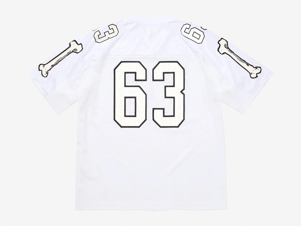 The Supreme Bones Football Jersey White puts a bold spin on classic athletic wear, merging sport structure with graphic street energy. Made from breathable mesh, it features skeletal-inspired graphics that pop against the clean white base. Striped sleeves and tackle-twill style branding nod to vintage gridiron uniforms, while the relaxed, boxy fit allows easy layering and all-day comfort. A statement piece rooted in sport with unmistakable Supreme attitude.