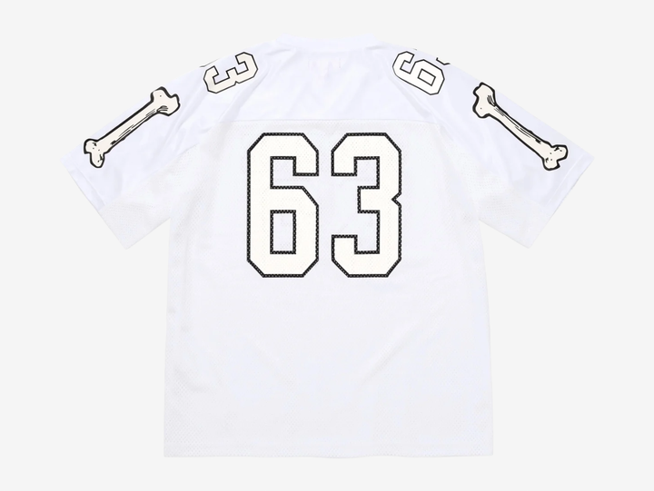 The Supreme Bones Football Jersey White puts a bold spin on classic athletic wear, merging sport structure with graphic street energy. Made from breathable mesh, it features skeletal-inspired graphics that pop against the clean white base. Striped sleeves and tackle-twill style branding nod to vintage gridiron uniforms, while the relaxed, boxy fit allows easy layering and all-day comfort. A statement piece rooted in sport with unmistakable Supreme attitude.