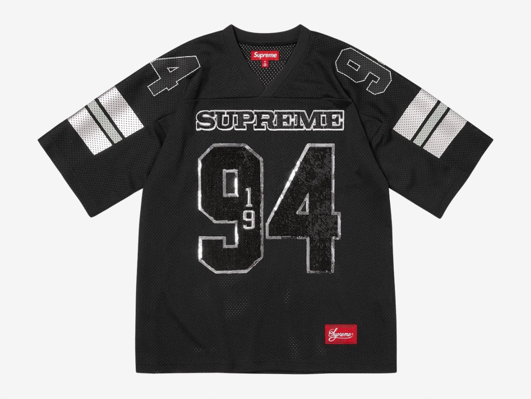 The Supreme Sequin Football Jersey Black blends classic gridiron style with bold streetwear energy. An athletic mesh base is overlaid with shimmering sequin detailing for standout impact, while tackle-twill style branding and contrast striping reinforce its on-field roots. Finished with a relaxed, boxy fit, this statement jersey merges sport heritage with signature Supreme attitude.