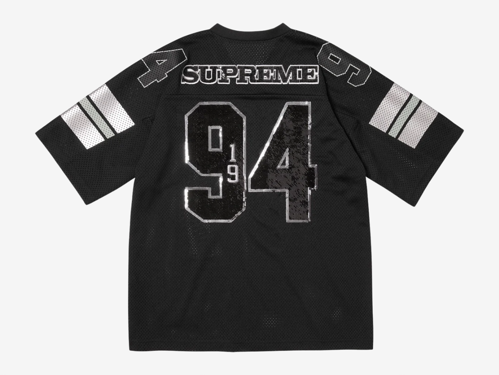 The Supreme Sequin Football Jersey Black blends classic gridiron style with bold streetwear energy. An athletic mesh base is overlaid with shimmering sequin detailing for standout impact, while tackle-twill style branding and contrast striping reinforce its on-field roots. Finished with a relaxed, boxy fit, this statement jersey merges sport heritage with signature Supreme attitude.
