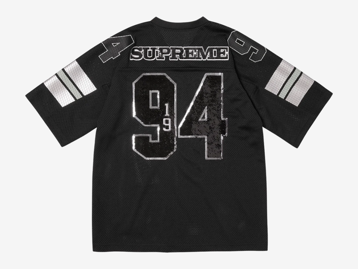 The Supreme Sequin Football Jersey Black blends classic gridiron style with bold streetwear energy. An athletic mesh base is overlaid with shimmering sequin detailing for standout impact, while tackle-twill style branding and contrast striping reinforce its on-field roots. Finished with a relaxed, boxy fit, this statement jersey merges sport heritage with signature Supreme attitude.