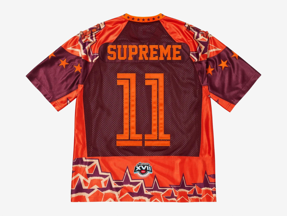 The Supreme Stars Football Jersey in Orange brings a bold athletic look with Supreme’s signature streetwear energy. Built from breathable mesh, it keeps the fit light, airy, and comfortable. The star graphics and contrast detailing give it a strong, standout presence, while the bright orange colorway adds real visual punch. This jersey is a great pick for anyone who wants a sporty Supreme piece that turns heads without trying too hard.