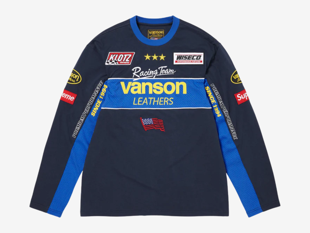 All cotton jersey with cotton mesh panels at chest and sleeves. Embroidered logo patches on chest and sleeves. Embroidered graphics on front and printed graphics on sleeves. Embroidered logo appliqué at back.