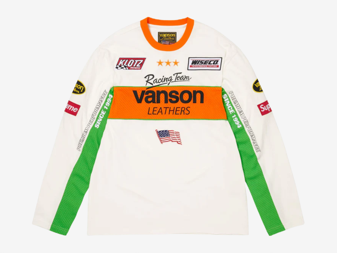 All cotton jersey with cotton mesh panels at chest and sleeves. Embroidered logo patches on chest and sleeves. Embroidered graphics on front and printed graphics on sleeves. Embroidered logo appliqué at back.