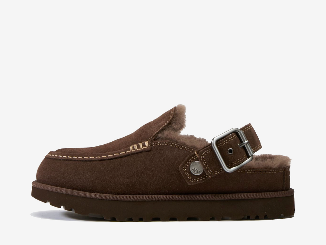 The UGG Goldenstar Evelina Clog Burnt Cedar features a smooth suede upper in a rich brown finish, detailed with decorative stitching and an adjustable heel strap. A soft UGGplush™ interior and lightweight sugarcane EVA outsole provide cushioning and everyday comfort.