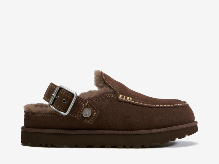The UGG Goldenstar Evelina Clog Burnt Cedar features a smooth suede upper in a rich brown finish, detailed with decorative stitching and an adjustable heel strap. A soft UGGplush™ interior and lightweight sugarcane EVA outsole provide cushioning and everyday comfort.