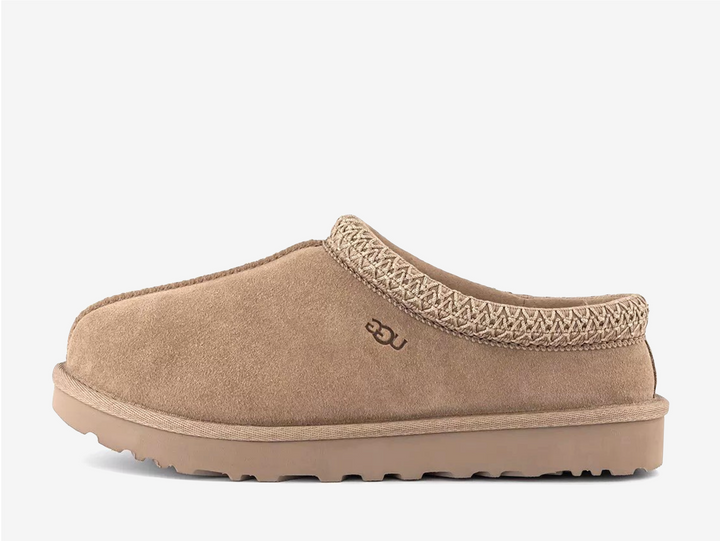 The Tasman II slippers are a sturdy and comfortable slip-on silhouette featuring the same durable outsole as the iconic UGG Classic Boot. Crafted with velvety suede, plush natural wool and embroidered braided detailing. In a stunning Mushroom colourway.