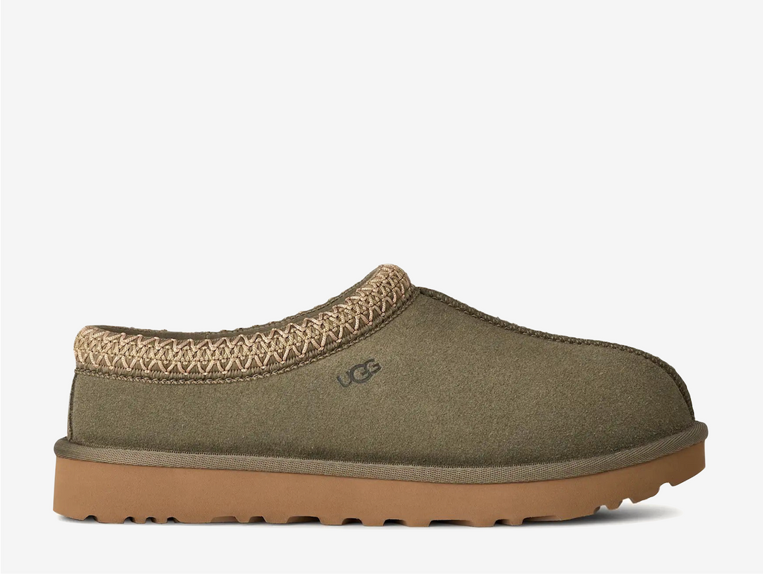 The Tasman II slippers are a sturdy and comfortable slip-on silhouette featuring the same durable outsole as the iconic UGG Classic Boot. Crafted with velvety suede, plush natural wool and embroidered braided detailing. In a stunning Moss Green colourway.