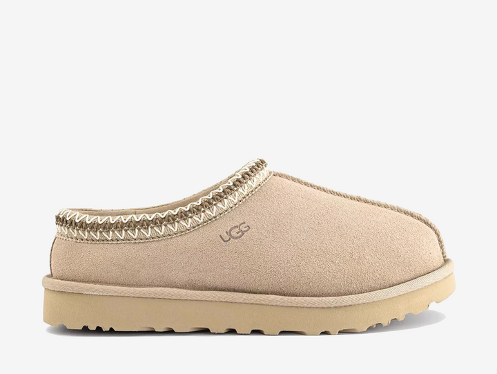 The UGG Tasman Slipper Moonlight features the iconic slip-on silhouette in a clean, light neutral finish. Crafted from soft suede with signature braid detailing and a plush lining, it offers everyday comfort with a versatile look.