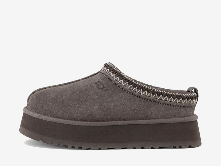 The UGG Tazz Slipper Dried Oregano features an earthy green suede upper paired with signature braid detailing around the collar. A soft lining and chunky platform sole complete the silhouette with added warmth, cushioning and height.