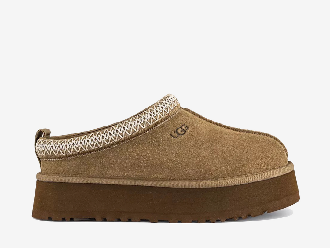 The UGG Tazz Slipper Light Bronze arrives in a warm neutral suede finish with signature woven detailing around the collar. Its plush lining and platform sole provide the familiar comfort of UGG with a more elevated silhouette.