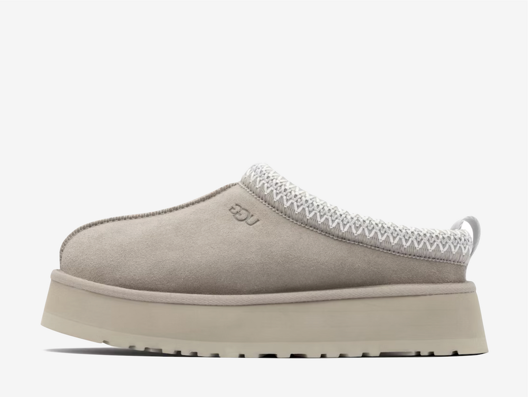 Exclusive UGG Tazz Slippers in a light grey and brown colourway. Featuring a sheep skin soft lining.