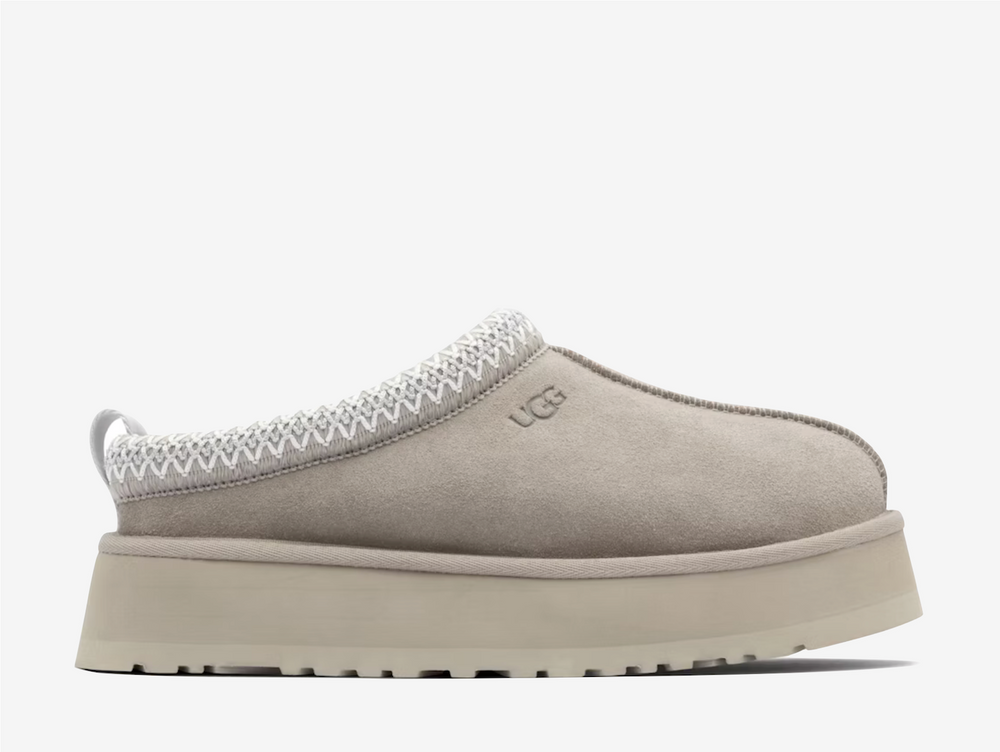 Exclusive UGG Tazz Slippers in a light grey and brown colourway. Featuring a sheep skin soft lining.