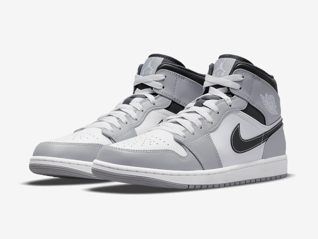 Classic Jordan 1 Mid shoes with a grey, white, and black colourway.