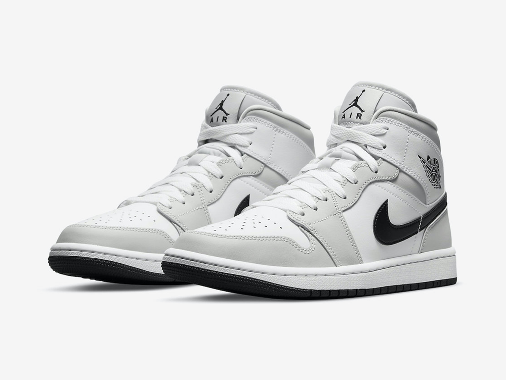 Classic Jordan 1 Mid shoes with a white and grey colourway.