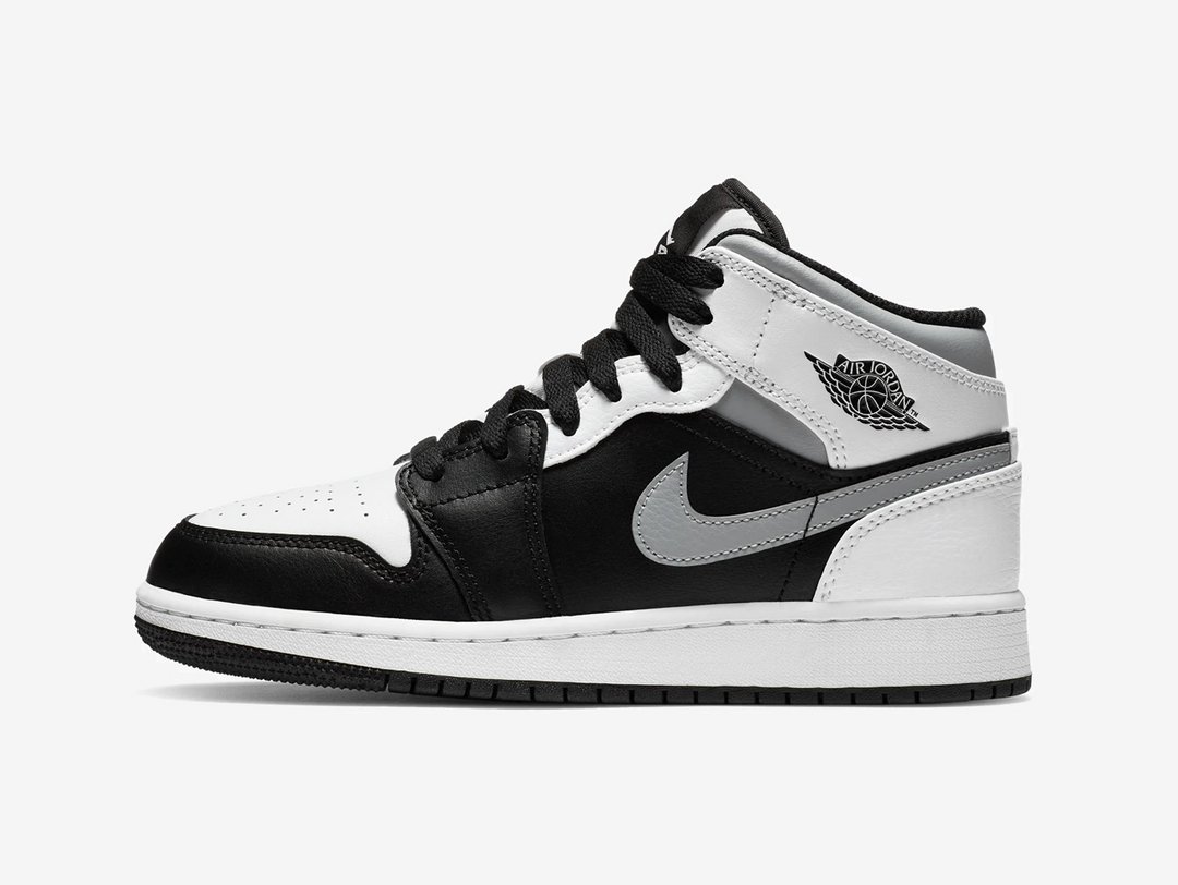 Timeless Air Jordan 1 Mid sneakers in a classic white, grey and black colour scheme.